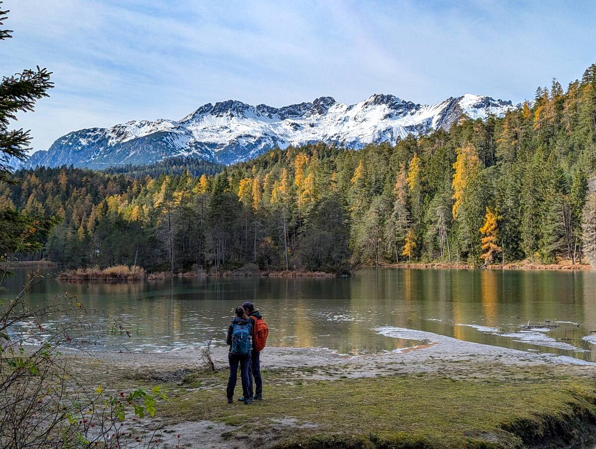 Hikers Admire Lake Weissensee And Snow-Capped Wetterstein Mountains In Tyrol