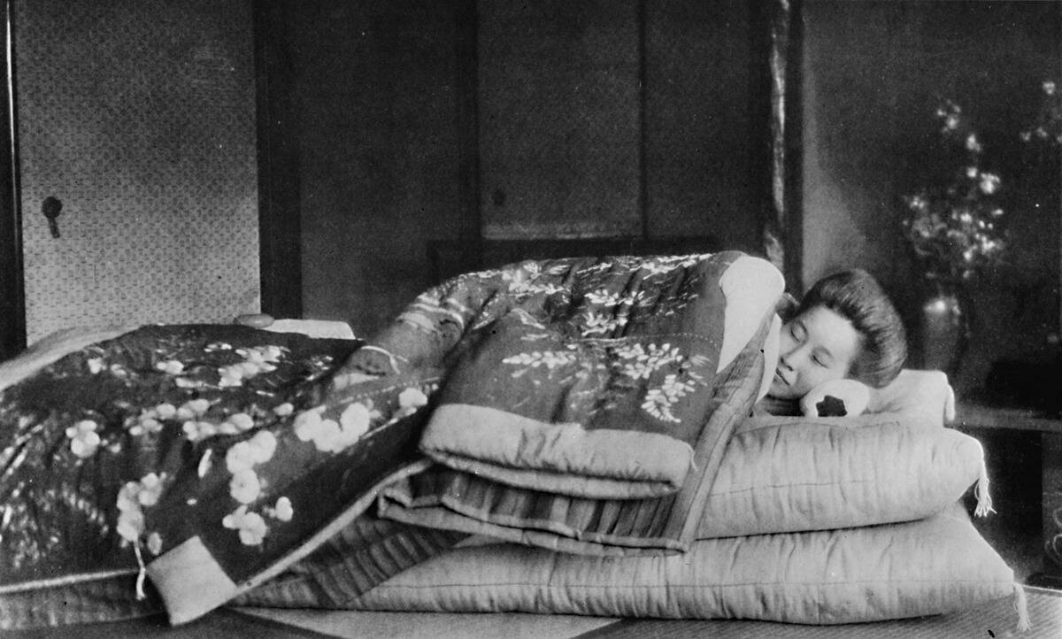 'Saki, the housekeeper sleeps on a mattress with hard pillow under a quilted kimono', c1900, (1921)