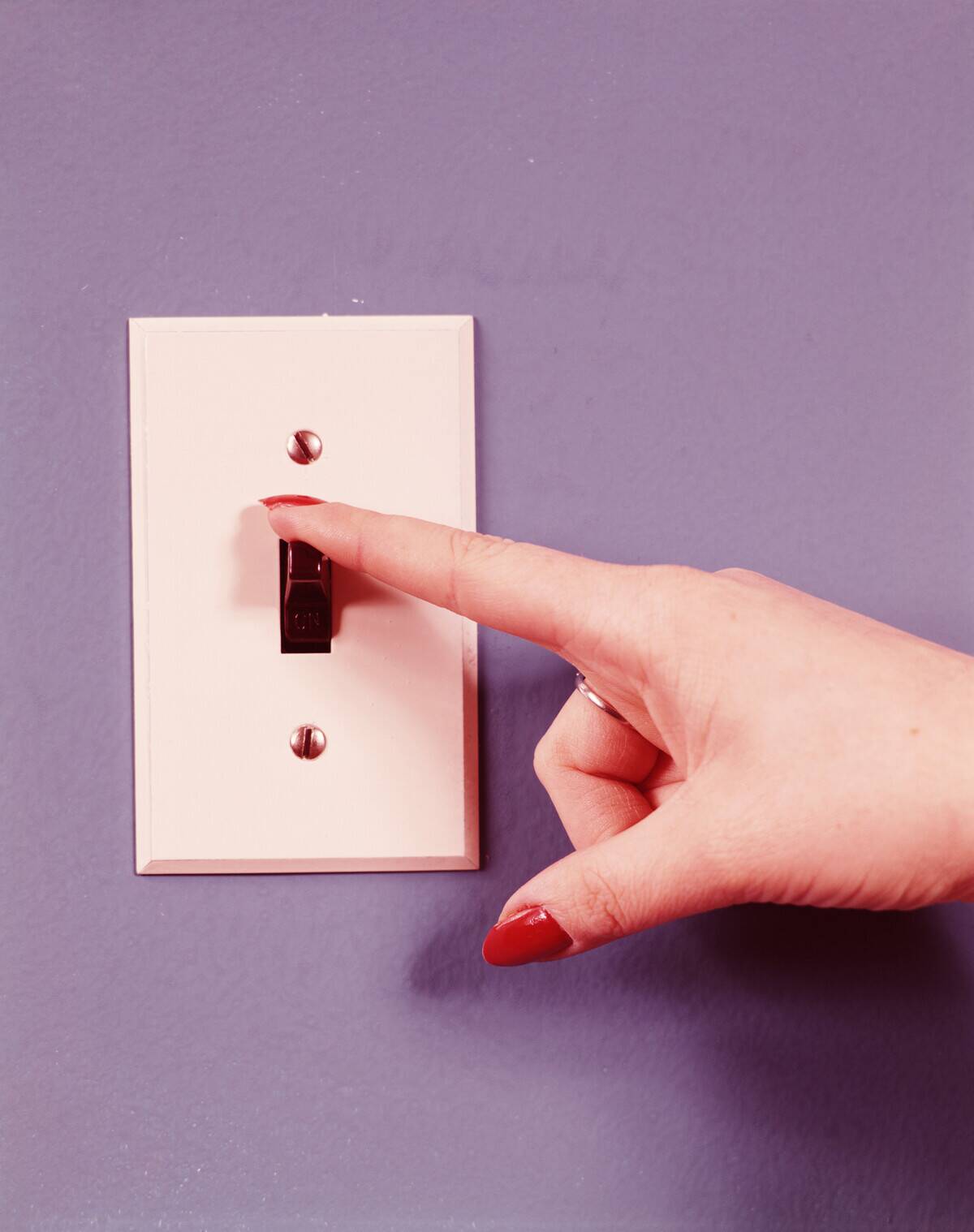 Woman turning off light swich