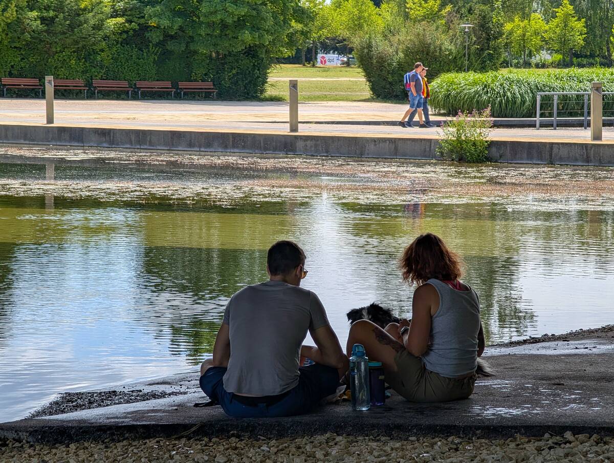 Young Couple Sitting By Stream In Shade