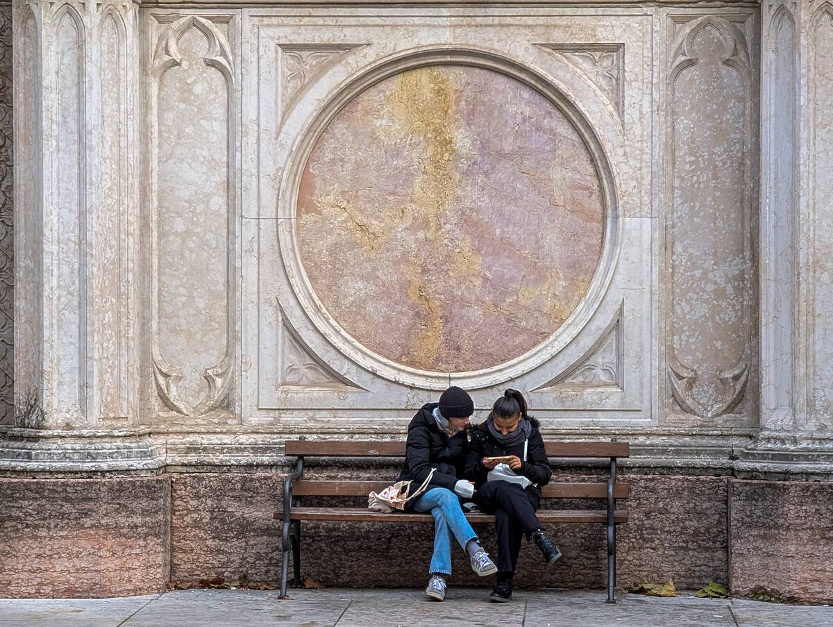 Young Women Use Smartphone On Bench By Marble Facade