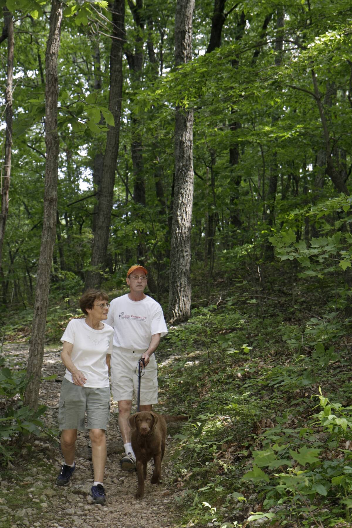 A couple walking with their dog on a trail at Roanoke Mountain.