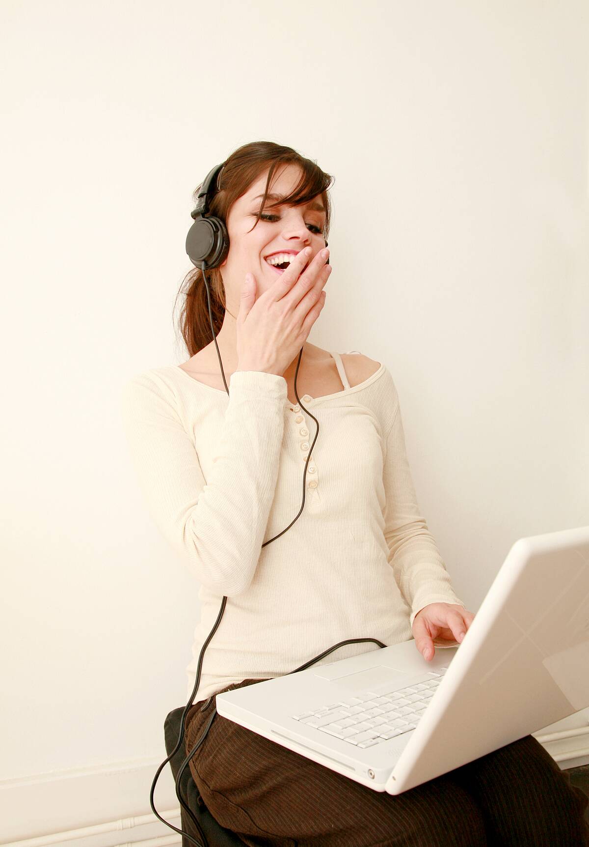 A good looking girl with a headphone and a laptop smiling, UK 2006