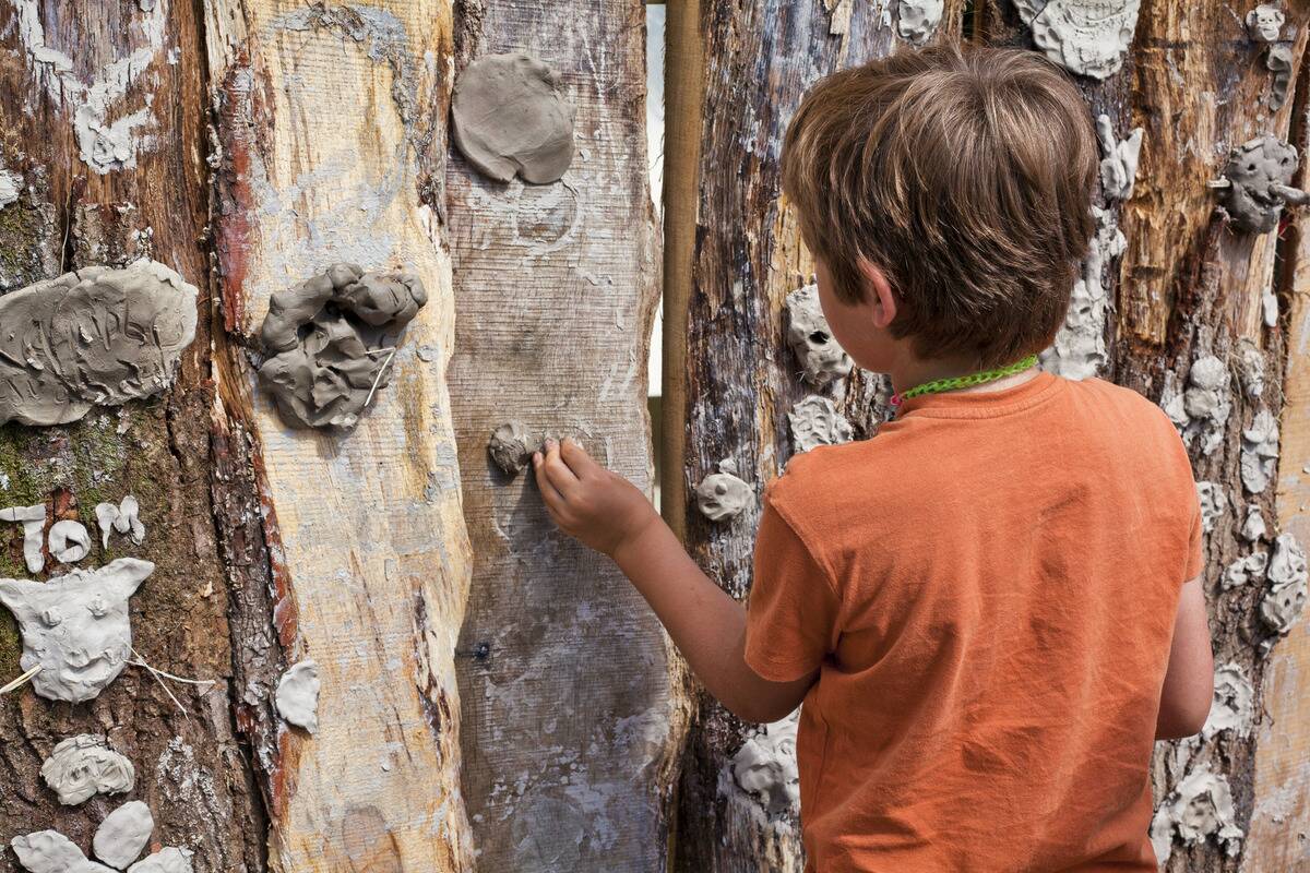 Boy Working at A Mud Grafitti Wall, Music Festival. Dorset, England