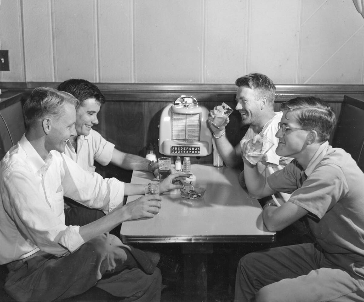 Four Young Men Drink Beer By Jukebox