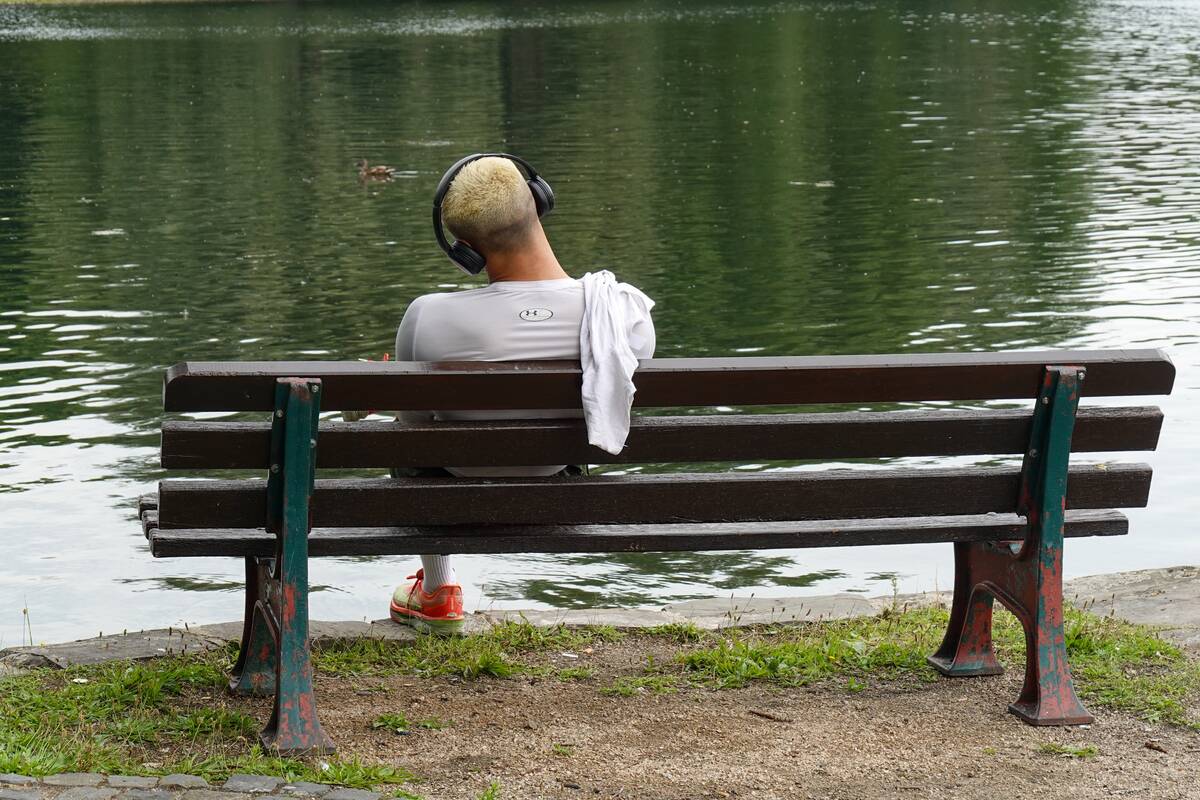Man Relaxing At Lake In Park