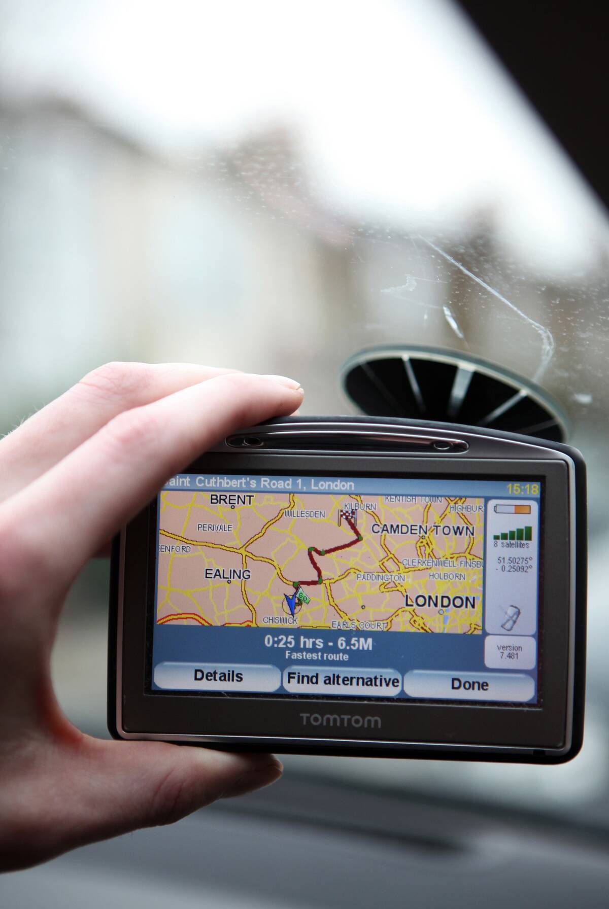 A driver adjusts his TomTom navigation system on a vehicle w