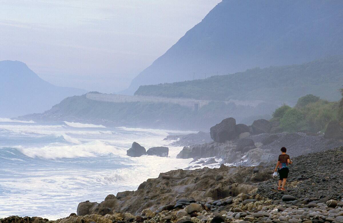 An Amis beachcomber collecting sea-washed marble pebbles, East Coast National Scenic Area.