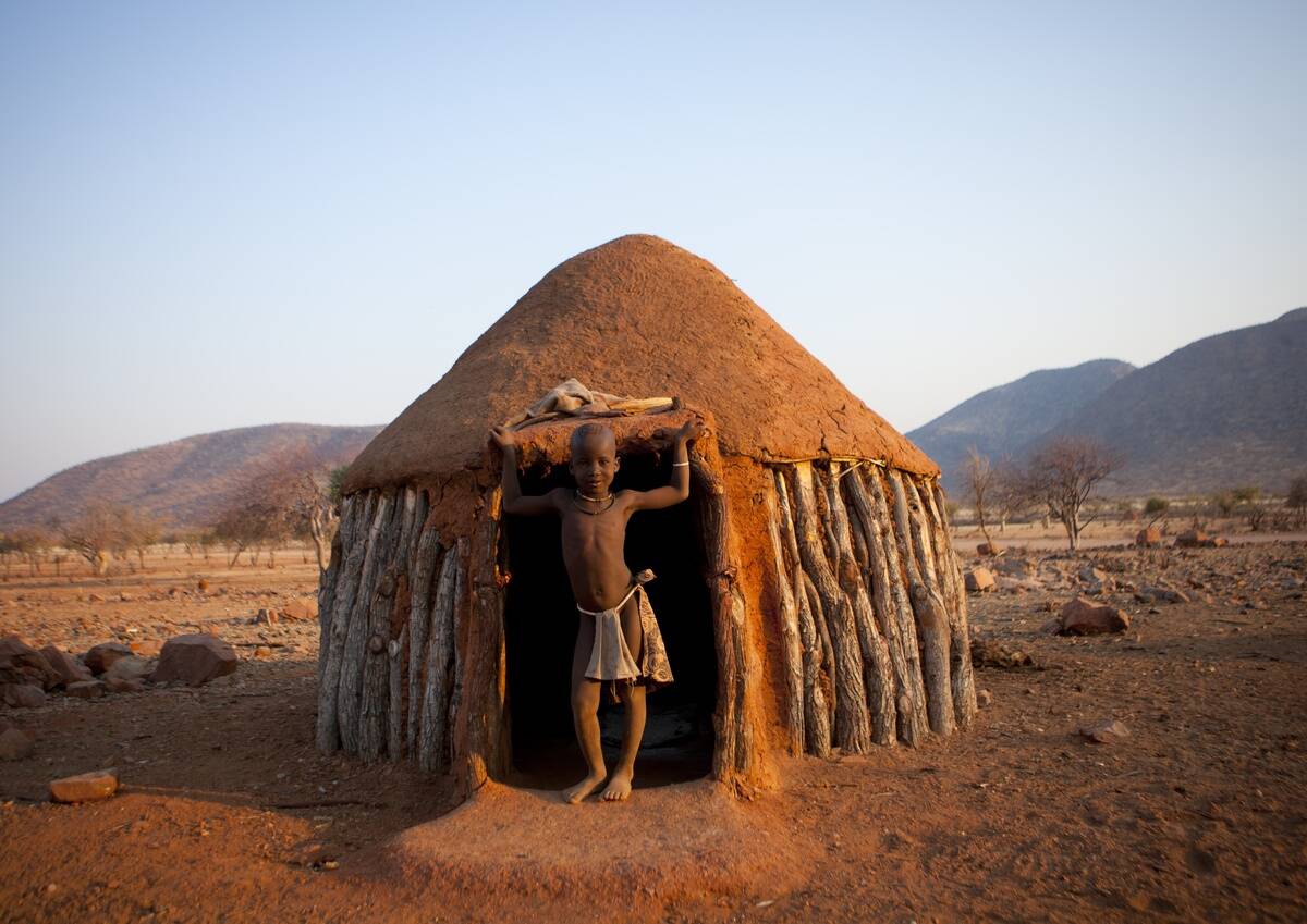 Himba Boy In The Entrance Of His Hut, In Okapale Area, Namibia On August 18, 2010 -