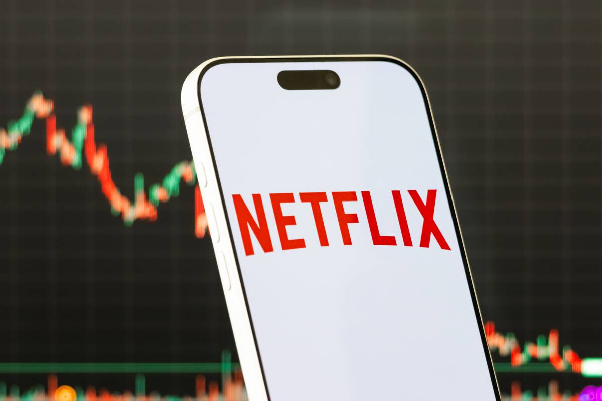 Netflix Logo Shown on Smartphone with Latest Stock Market Chart