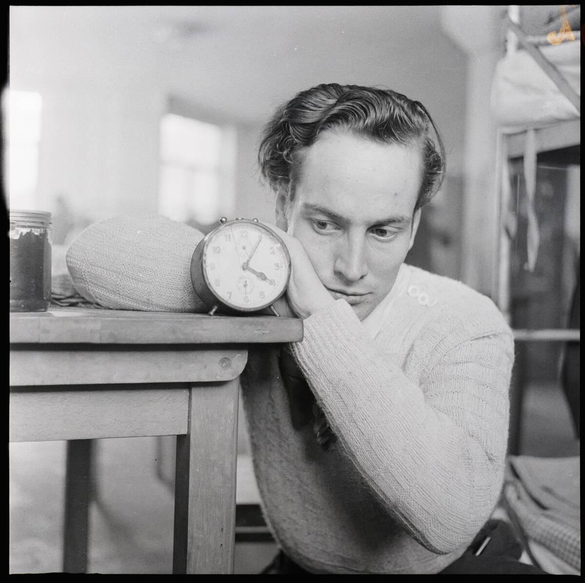 Refugee Leans Beside A Clock