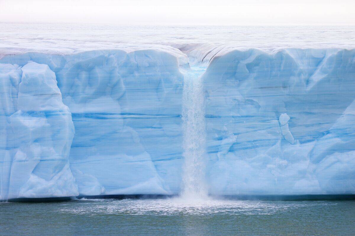 Waterfall at edge of the Brasvellbreen glacier from the ice cap Austfonna debouching into the Barents Sea