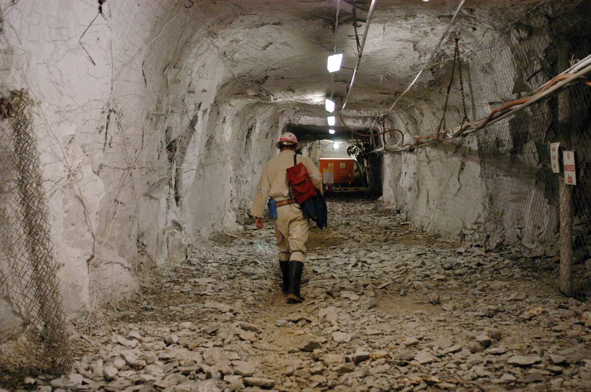 A miner is walking several kilometers below ground at AngloG
