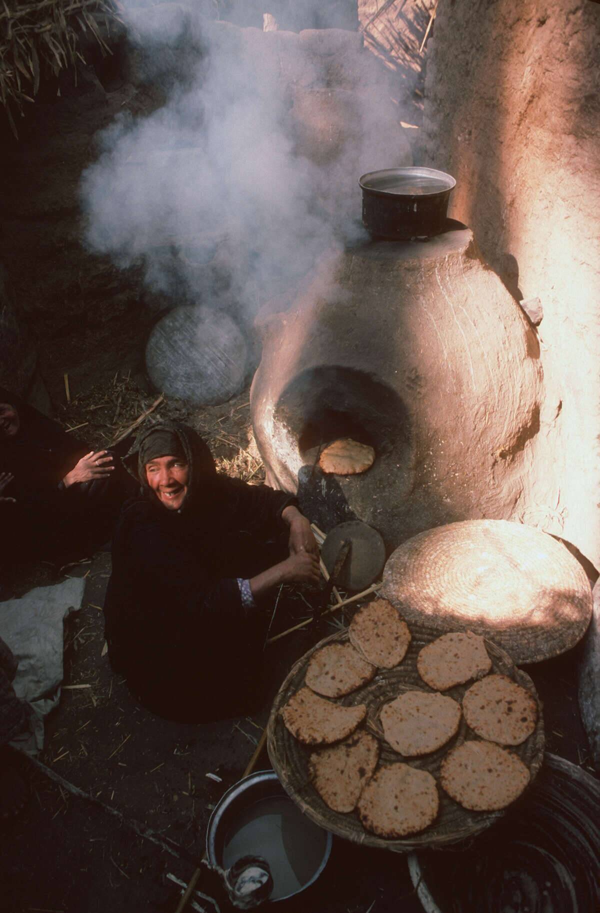 A women making bread in a clay oven...