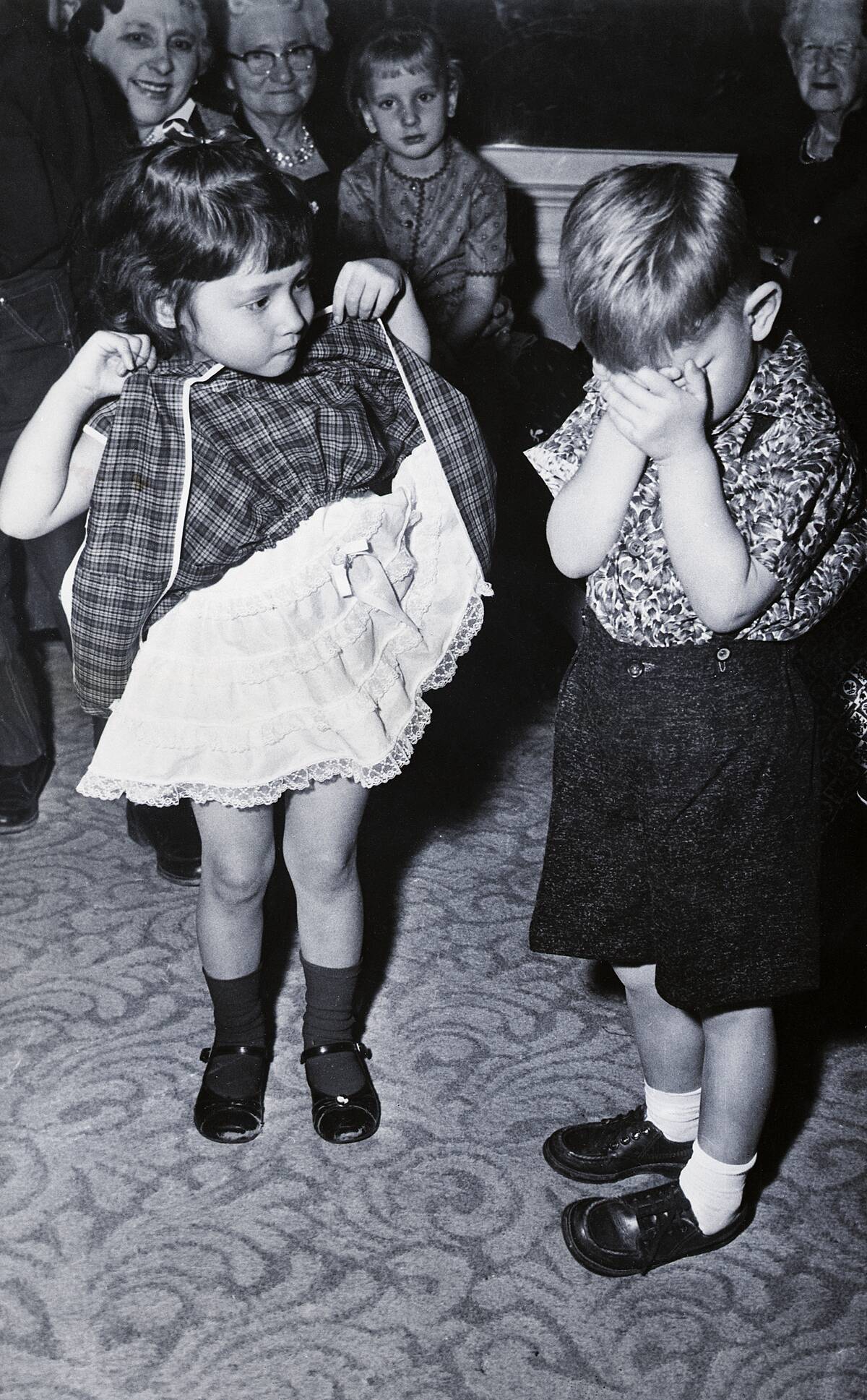 Boy Covering Eyes as Girl Raises Skirt