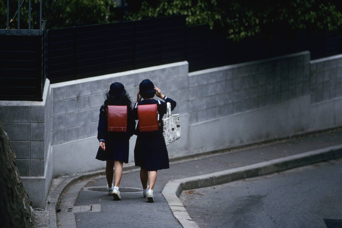 Schoolgirls Walking Along Sidewalk