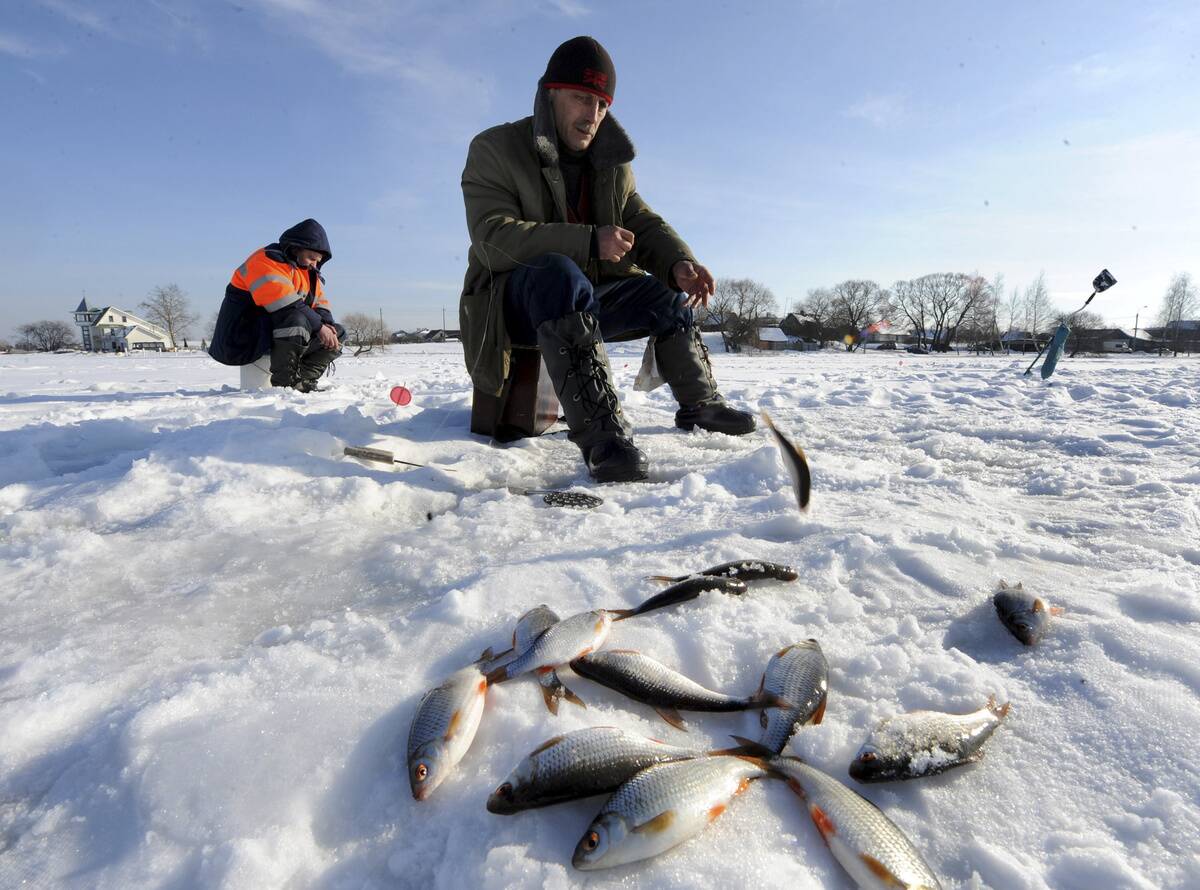 Belarussian men ice-fish on a frozen lak